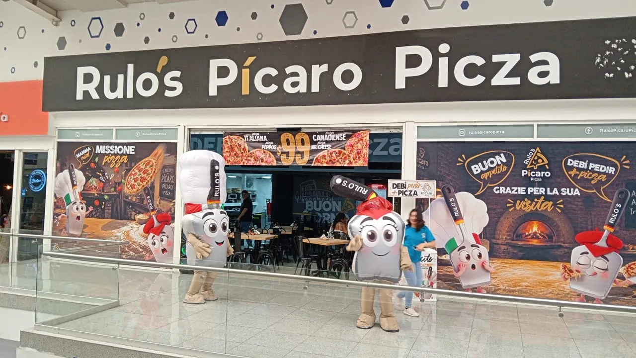 Pícaro y la Pícara frente a la fachada de Rulo's Pícaro Picza en Plaza Coacalco